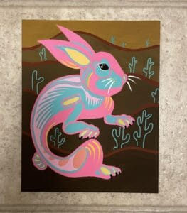 painting of pink, blue, and yellow rabbit, cacti outlines in background